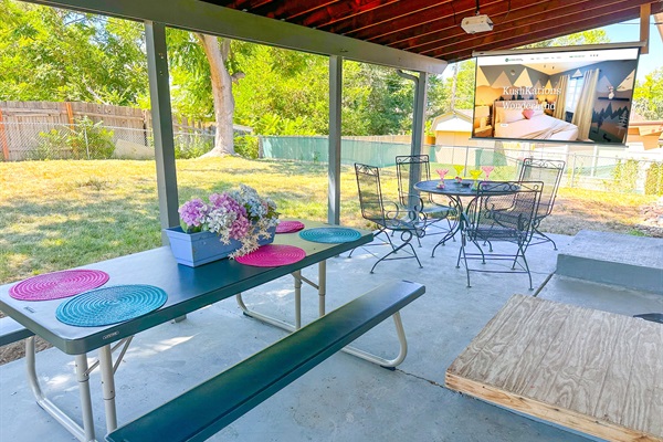 Your private backyard escape with cozy seating, a dining table, and a projector for ultimate relaxation!