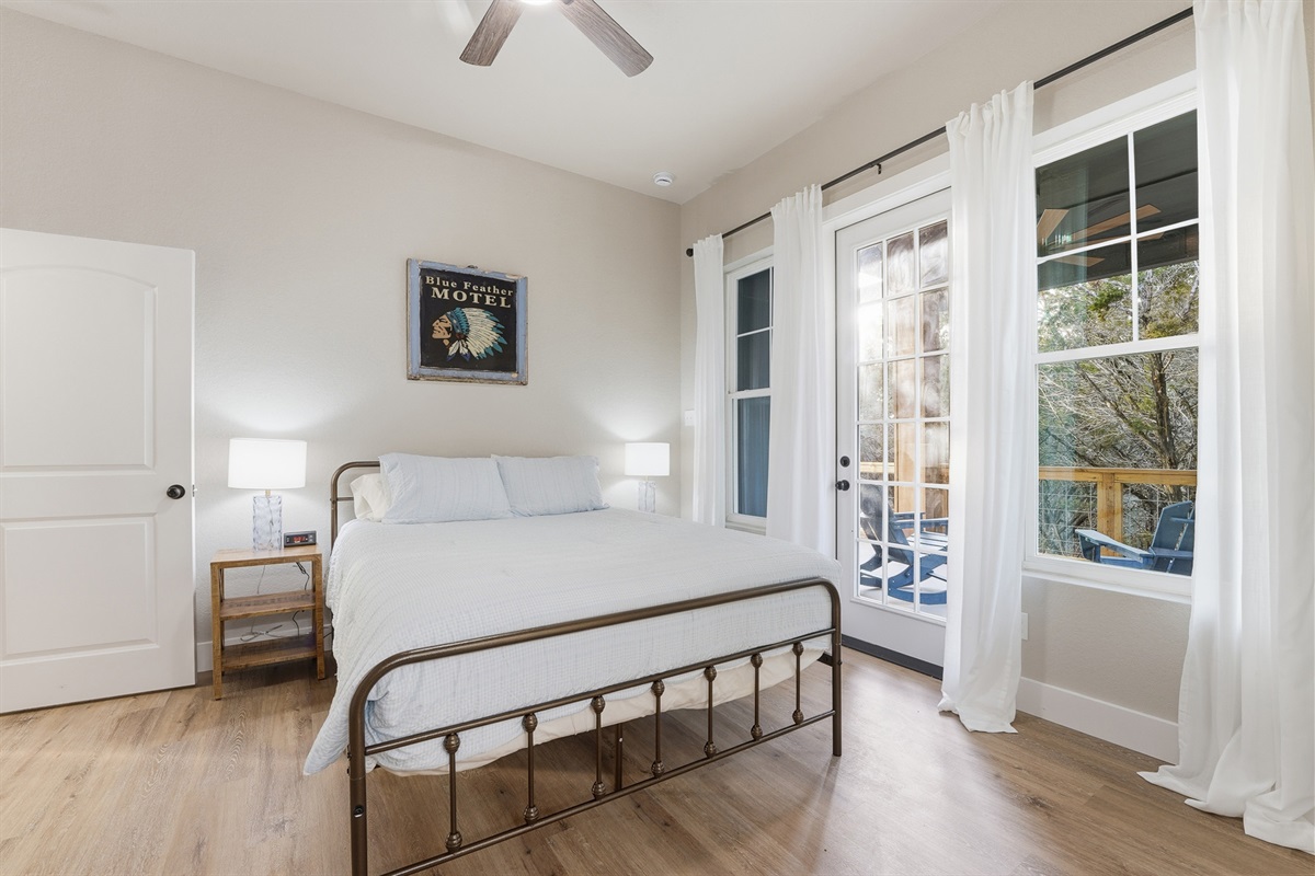 Bedroom Two with deck access and natural light overlooking the surrounding trees.