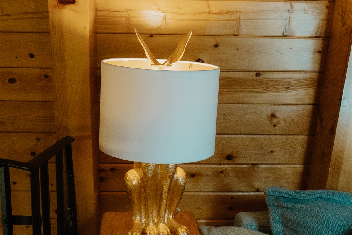 Warm lighting and curated décor elevate the loft lounge of this A-frame cabin. From the vaulted wood ceilings to cozy seating, every detail invites relaxation in this peaceful Show Low mountain escape.