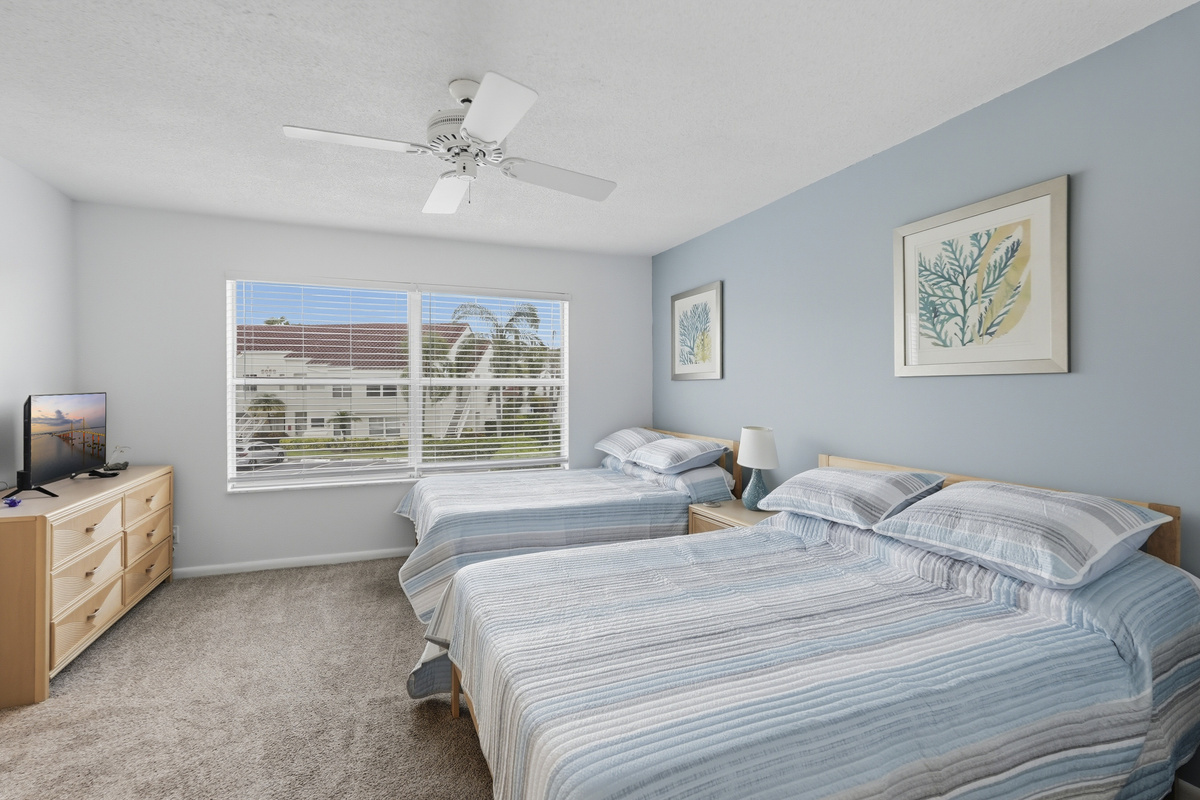 Comfortable and welcoming, the guest bedroom features two full-size beds, a private ensuite bathroom, and a Smart TV, making it a great space for family or friends to relax and enjoy a restful night's sleep.