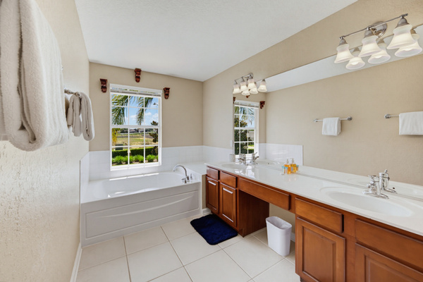 Primary en-suite w/ walk-in shower, garden tub, & dual vanity 
