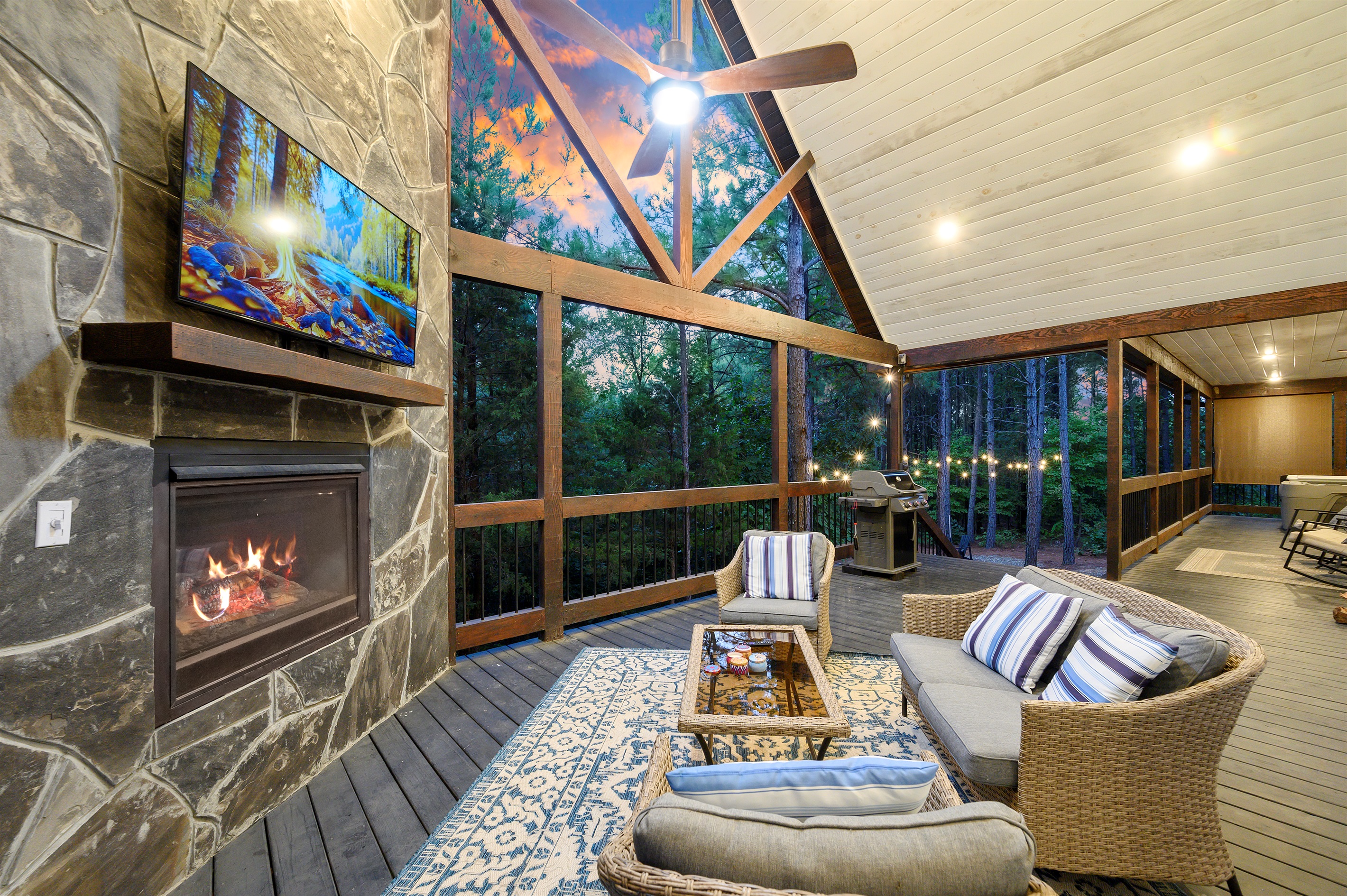 Check out your outdoor lounge—full seating setup, cozy fireplace, and even your grill in the corner. Ideal spot for fireside chats, BBQs, and enjoying those forest vibes!