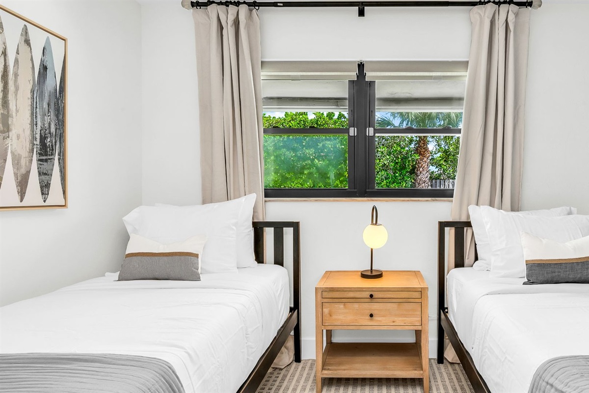 This light-filled twin bedroom combines comfort and style with coastal surf accents, two cozy twin beds, and premium linens. Guests will love the ROKU TV for entertainment and the abundant storage space, all ideally situated across from the guest bath.