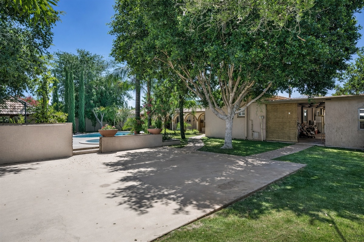 This expansive backyard offers mature trees, open green space, and room to relax, play, or gather under the Arizona sun.