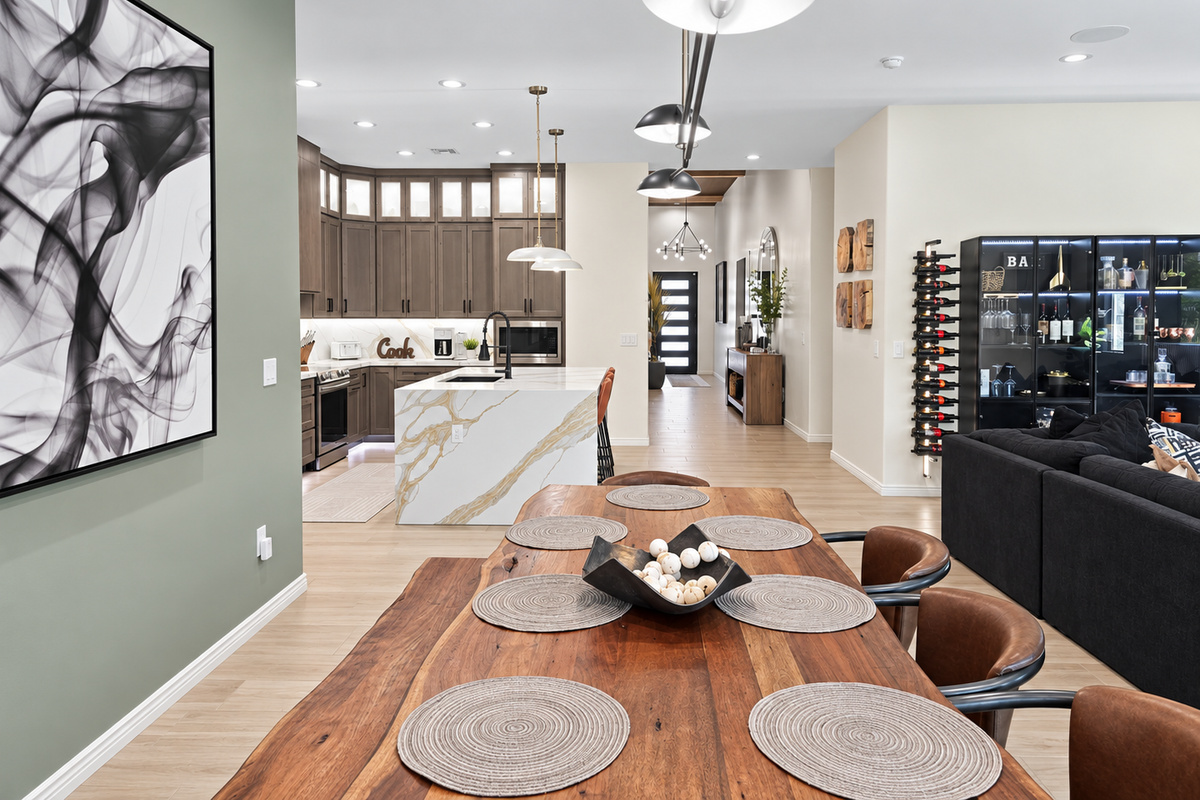Custom live edge wood dining table with seating for 8 and dramatic Restoration Hardware light fixture creating a sophisticated focal point.