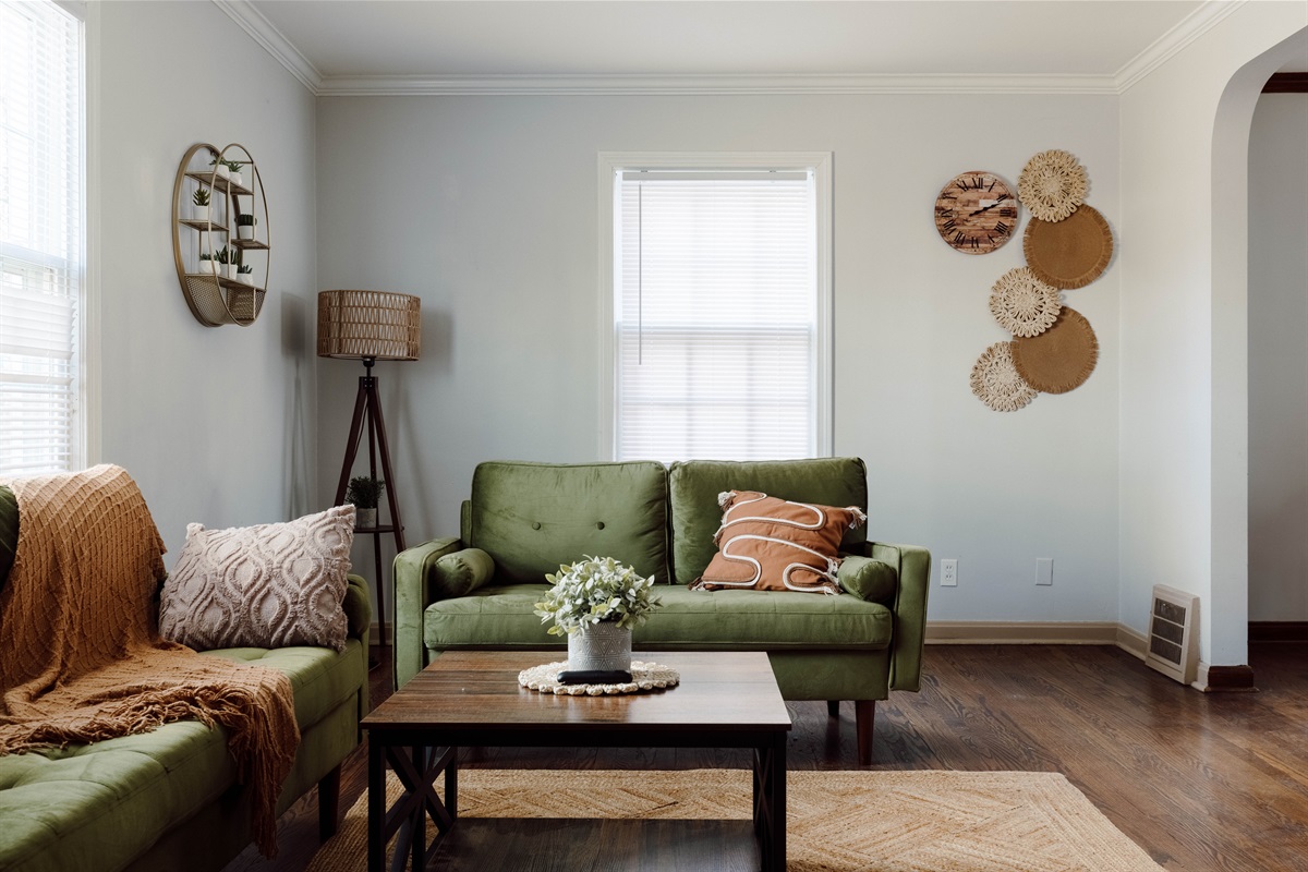Living room with green velvet sofas, a wood coffee table and a jute rug