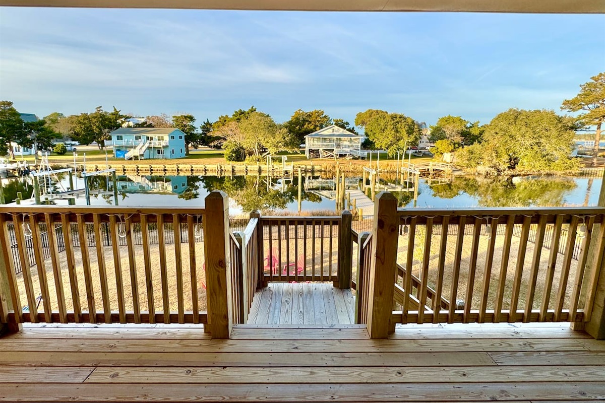 Private backyard dock with boat lift and fillet table, fenced-in backyard, fire pit with Adirondack chairs, hammocks, propane grill, picnic table, outdoor shower, expansive waterfront back deck with table and seating, neighborhood boat ramp and dock