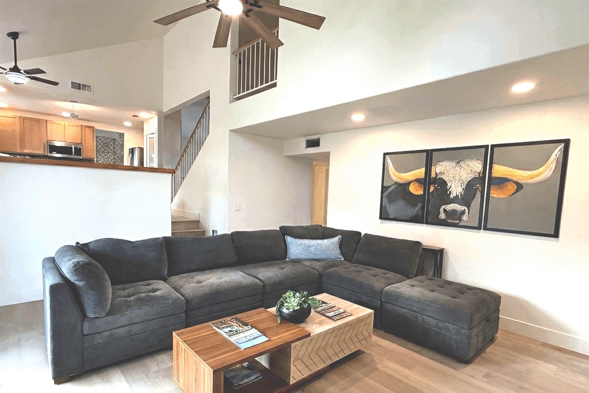 Large living room has an extra large sectional, individual chairs, big screen smart TV, board games, two different areas to charge your devices.