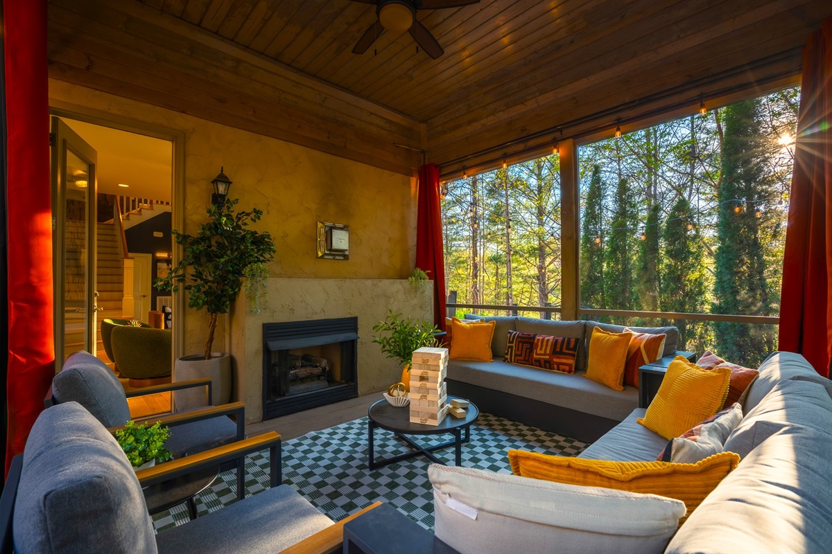Screened-in porch with fireplace and wooded views - an ideal spot to unwind in Asheville’s fresh mountain air