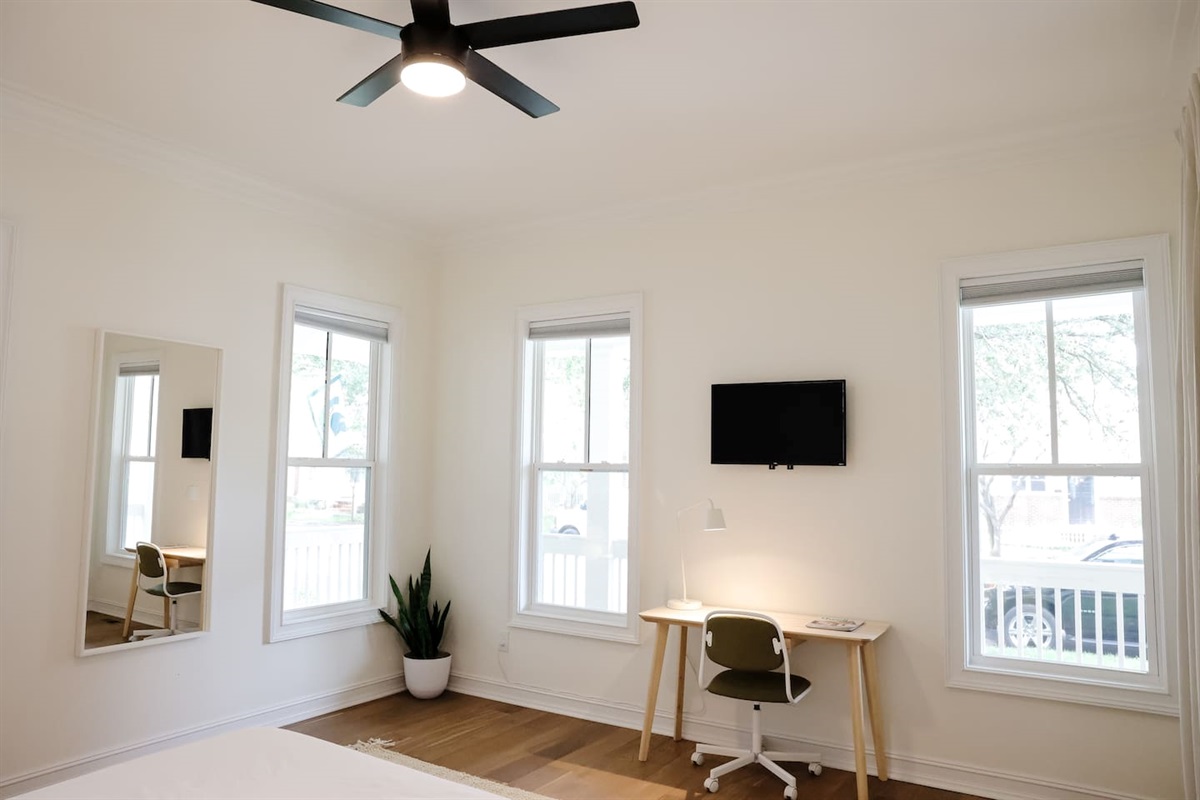 The downstairs bedroom is an airy oasis. Featuring custom art and headboard - the spacious room has a queen size bed, a walk-in closet, a desk for work-from-home, smart TV and direct access to a full bathroom.
