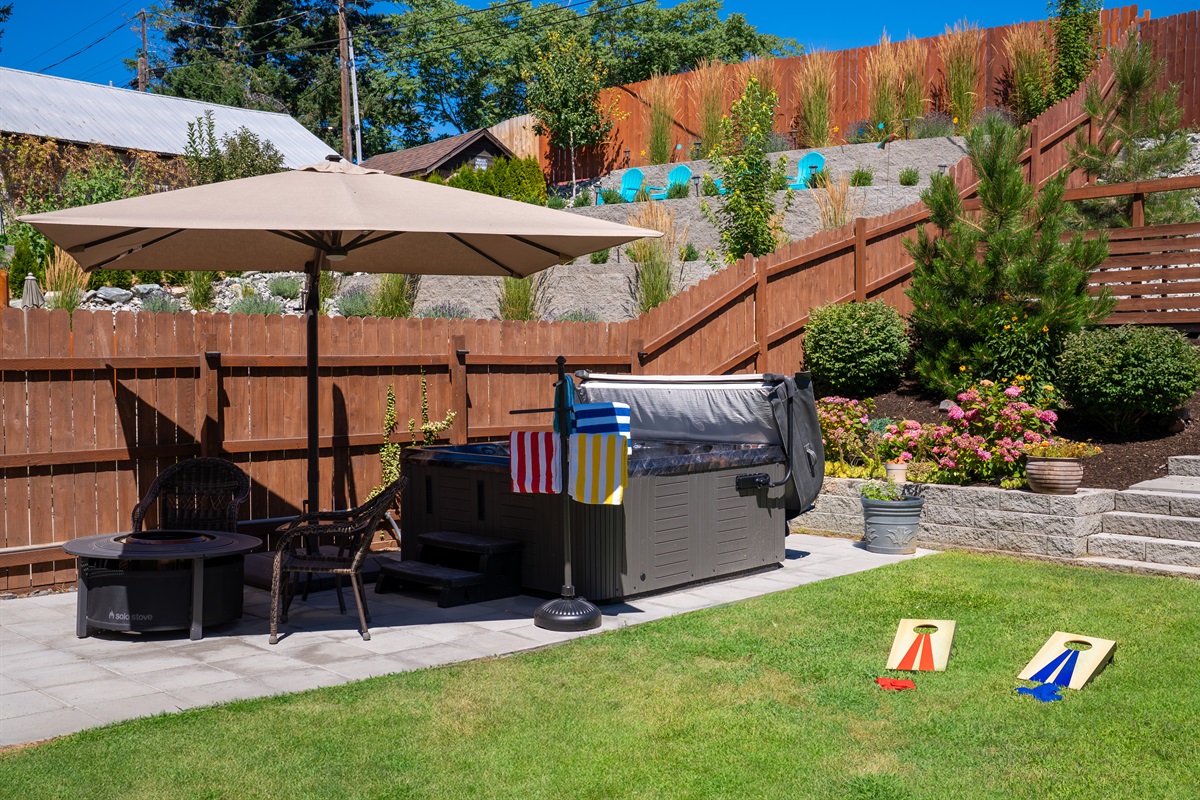 Backyard summer oasis with 6-7 person hot tub and mini corn hole set