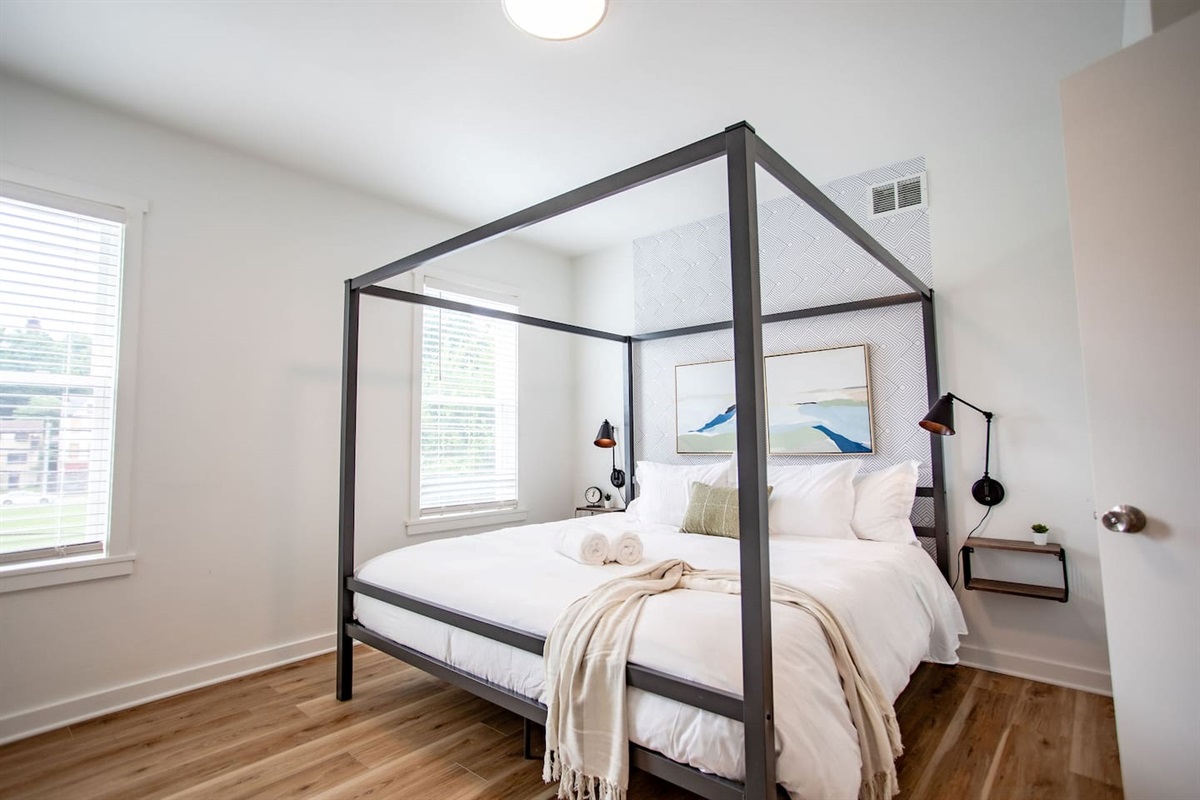 Cozy bed with a stylish bedframe, offering both comfort and a modern aesthetic that enhances the overall look of the room.