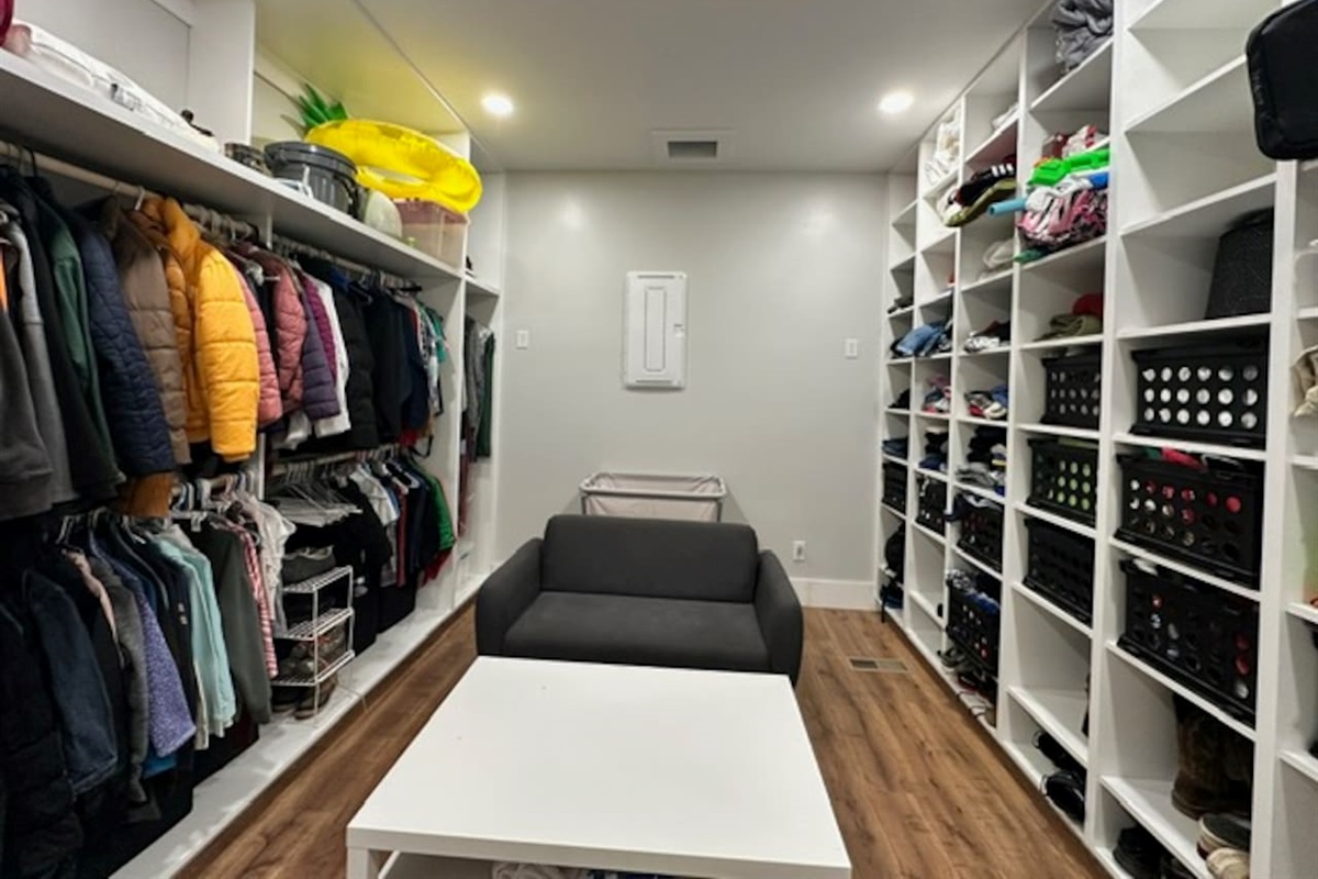 This massive laundry room includes a laundry chute from 2nd floor, a giant rolling laundry cart, a place to sit and fold clothes, and a table to organize. Plenty of space here to store your items that you don't need in your bedrooms during your stay.