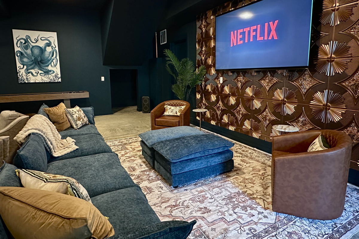 Movie night in the Octopus Room — a big screen, a deep sectional and a copper feature wall for atmosphere.
