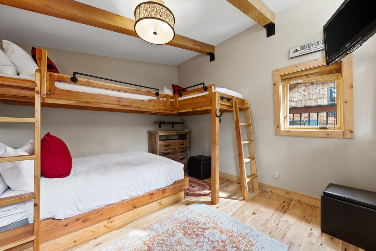 Backyard bungalow with twin-over-queen bunk and twin loft bed. Tv in upper right corner. Bungalow is heated with deadbolt locking door. 