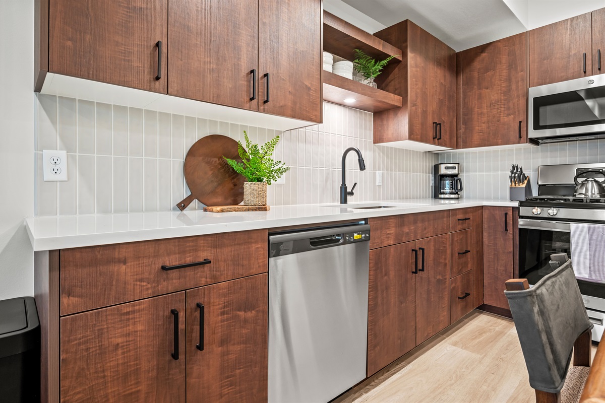 Rich cabinetry, quartz counters, and modern fixtures create a kitchen that’s as beautiful as it is functional.