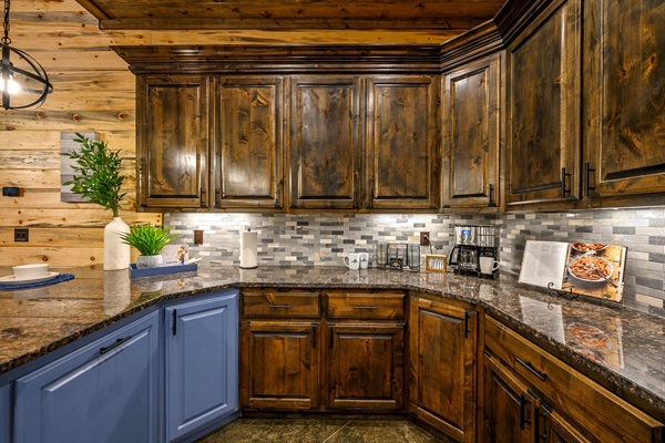 Chef’s kitchen with rich wood cabinetry and a stylish blue accent island.