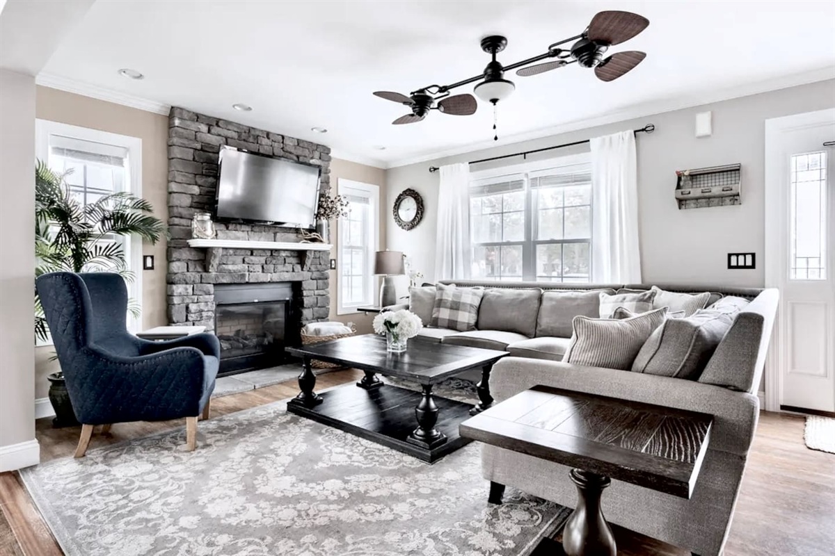 Unwind in this cozy living room featuring a stunning stone fireplace and flat-screen TV. With a plush sectional and stylish wingback chair, there’s plenty of room for everyone to relax.