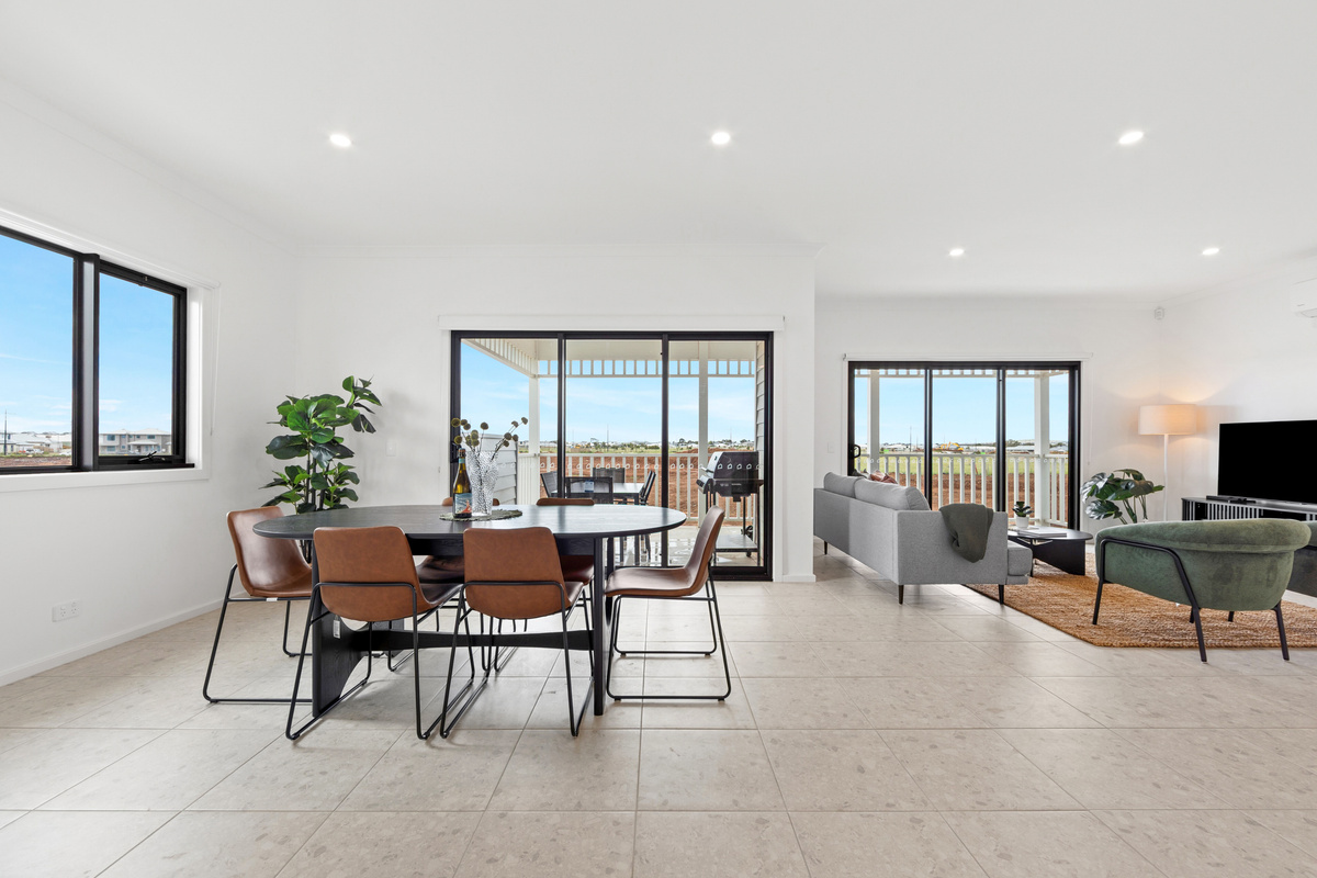 Dining area with sliding doors to the balcony, next to the lounge with TV and sofa.