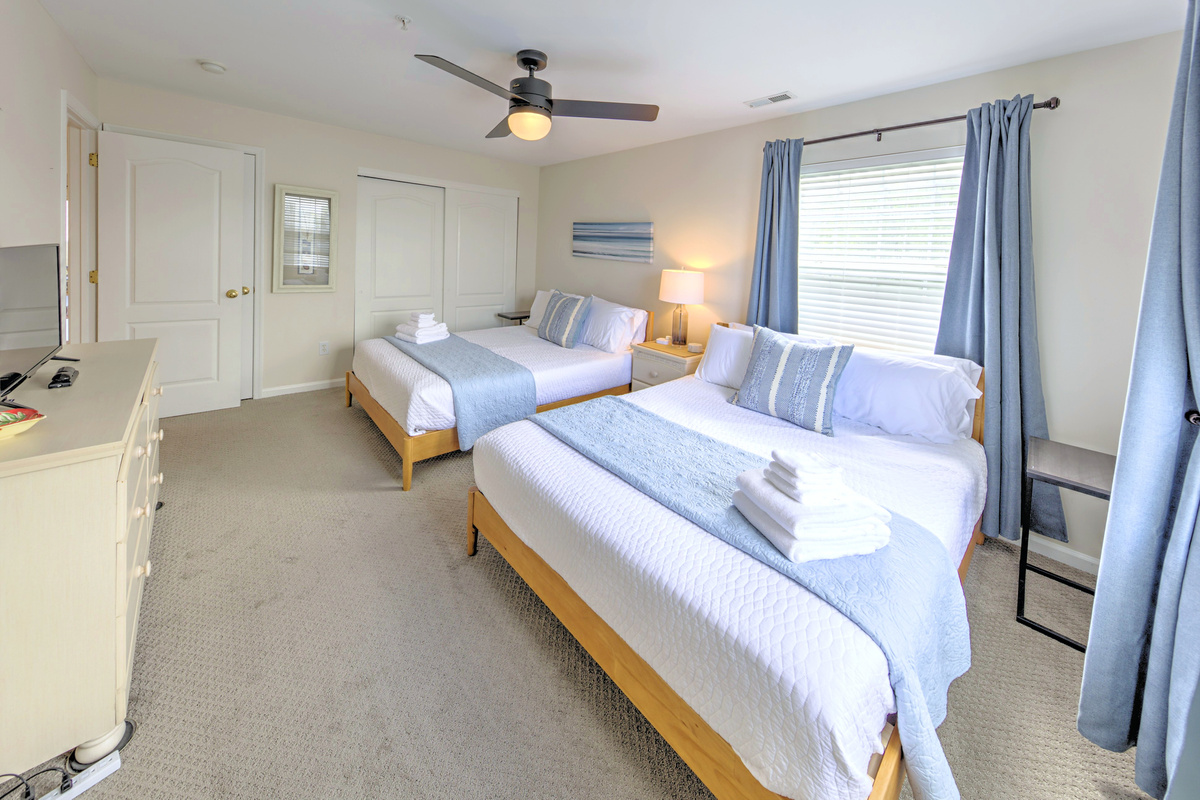 Fresh linens provided and beds professionally made before arrival—no linen rentals required.

Bedroom 2: Bright and airy retreat with two queen beds and serene coastal decor!