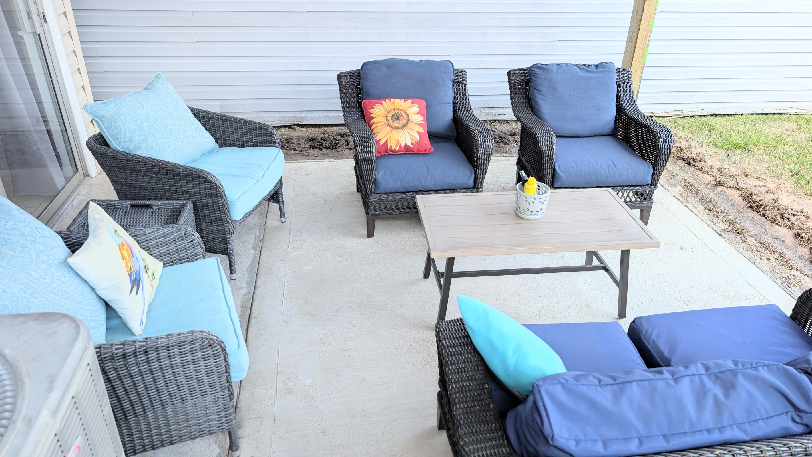 The covered patio offers plush seating and a fenced courtyard, creating a comfortable and private outdoor space to relax.