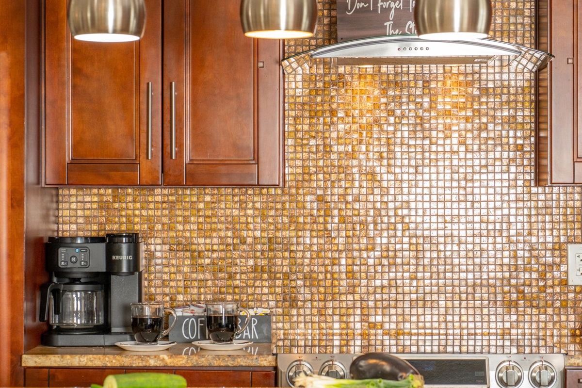 The rich wood cabinets and gold-hued surfaces pair beautifully with contemporary stainless fixtures for a balanced, stylish kitchen.