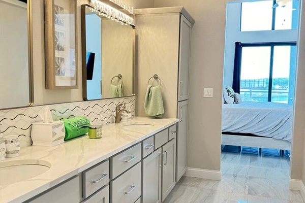 Master bathroom has double sinks, large closet, towels, and toiletries. 
