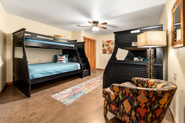 A spacious bunk room designed for kids, teens, and groups, featuring two sturdy bunk beds with plenty of sleeping space. Comfortable bedding, a cozy sitting area, and colorful lake-inspired touches make this a fun and inviting retreat after a day on the wa