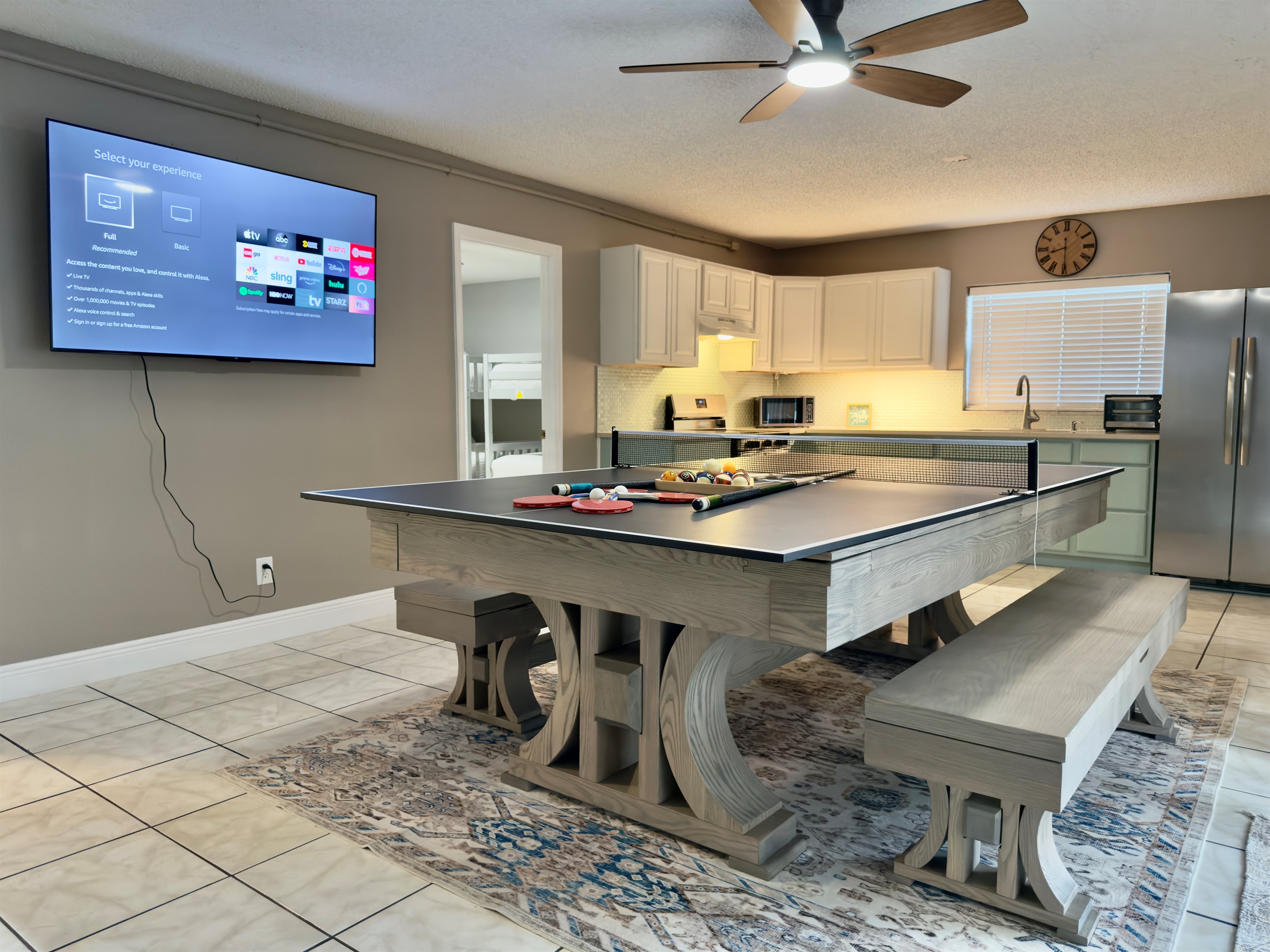 The room is thoughtfully designed with soft neutral tones, tile flooring for easy cleanup, and a ceiling fan to keep you cool while the action heats up.