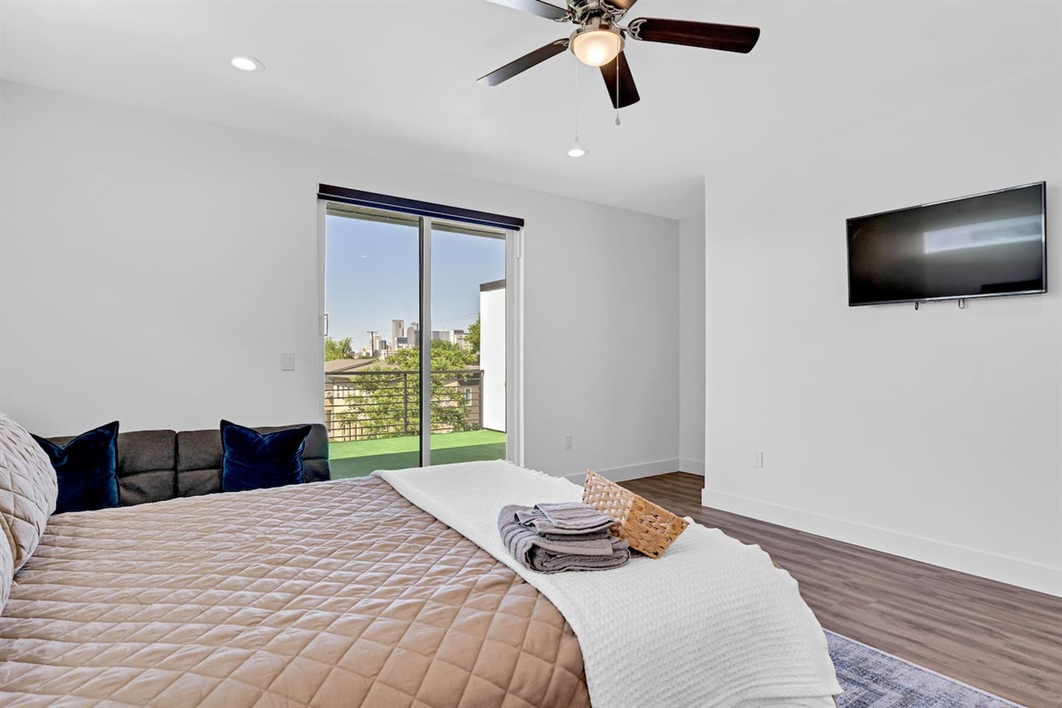Relax and unwind in a spacious bedroom with city skyline views and private balcony access—perfect for morning coffee or evening sunsets.