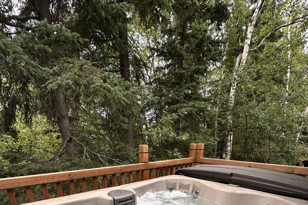 The shared hot tub on the main patio among the trees