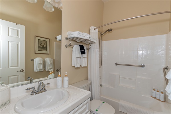 Bright bathroom with shower-tub combo, fresh towels, and clean modern finishes