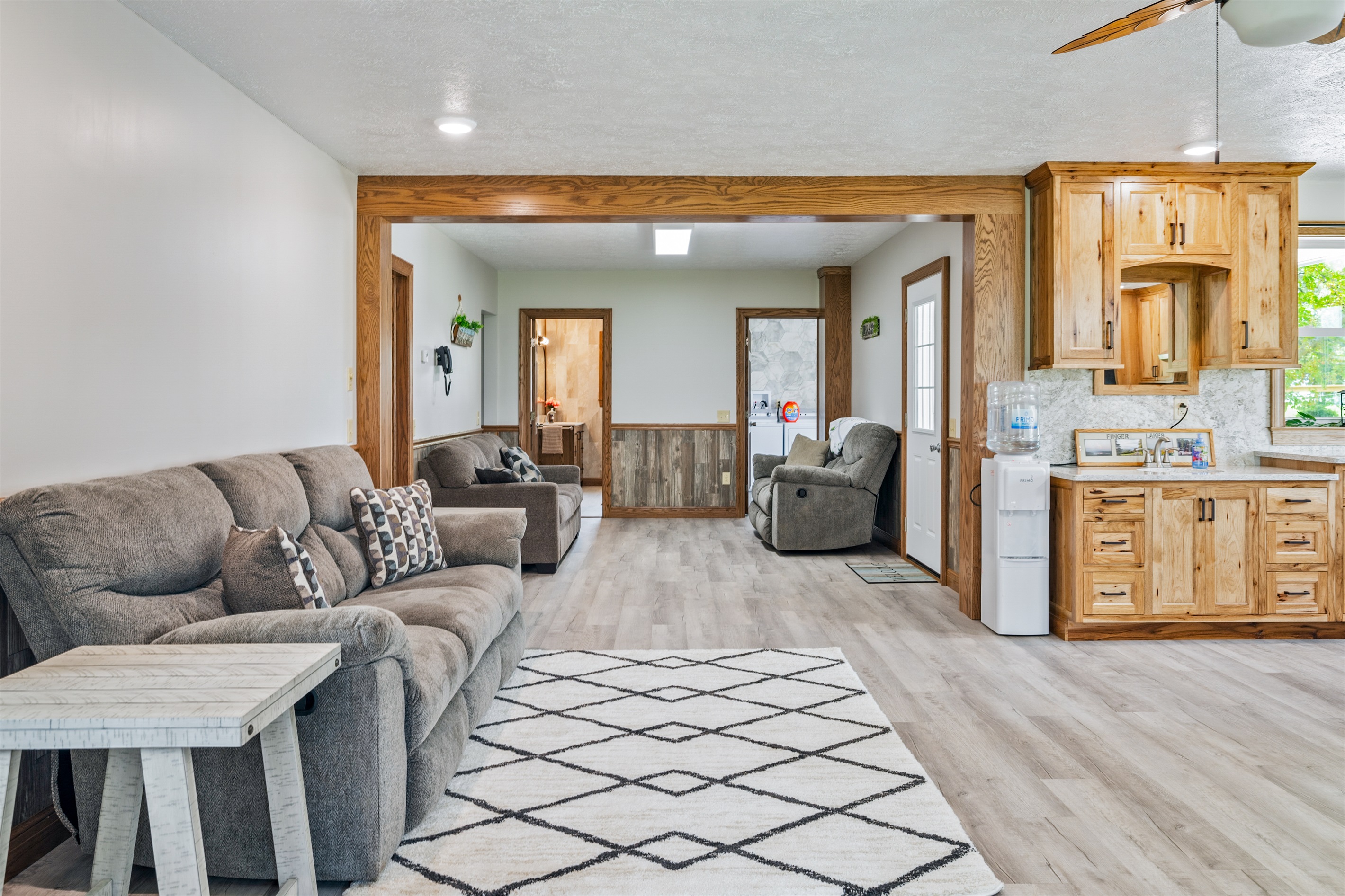 Spacious open-concept living and dining area with natural light, comfy recliners, and a seamless flow into the kitchen. Ideal for entertaining!