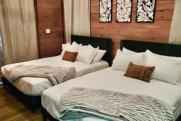Bedroom with two queen beds, modern art, and plush linens