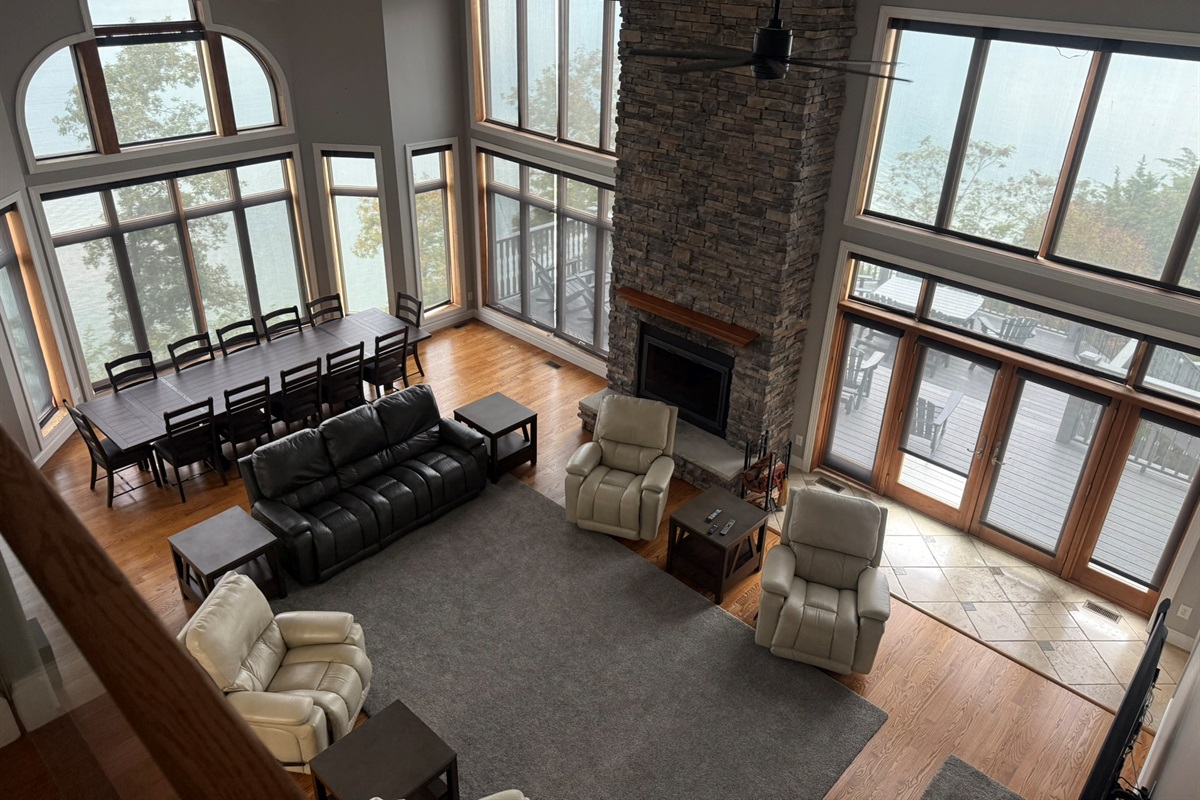 Living room with 20 ft ceiling, large windows with full view of Douglas Lake and Mountains on multiple sides, with doors to 2 porches (one out back and one next to the kitchen)