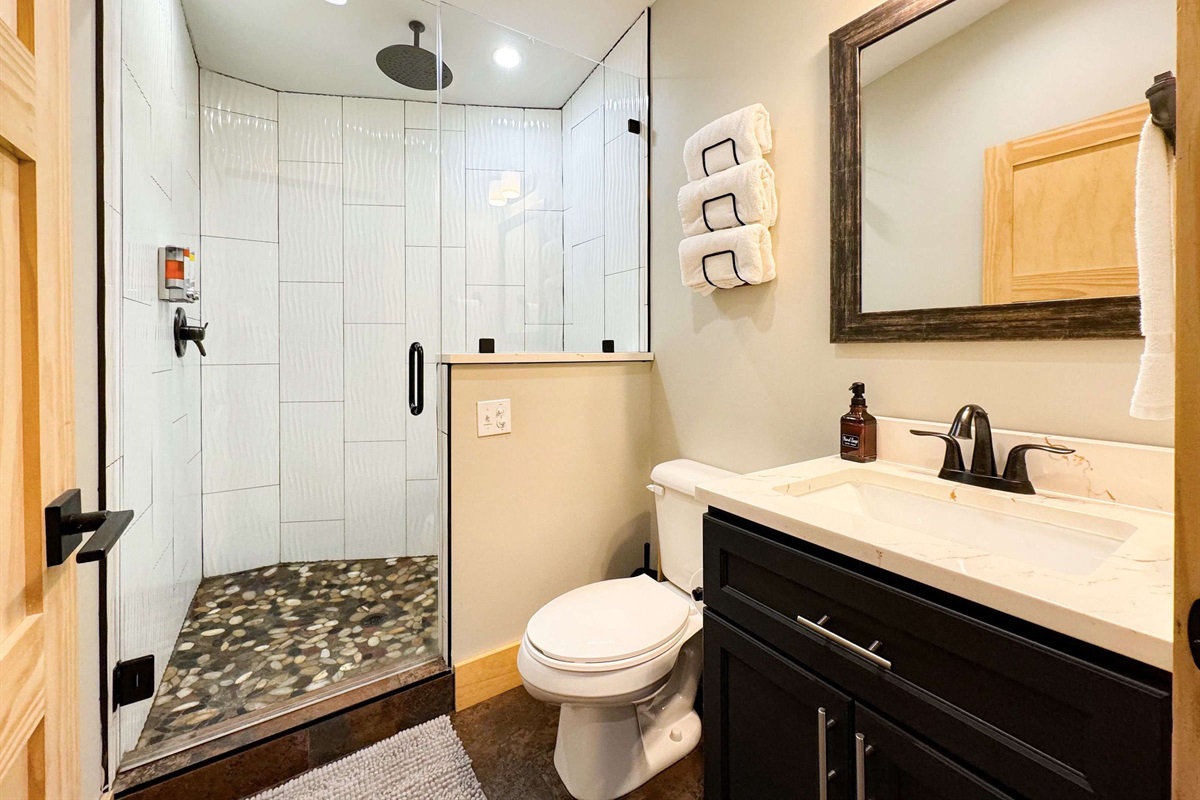 unique full bathroom with rain head shower and bench.