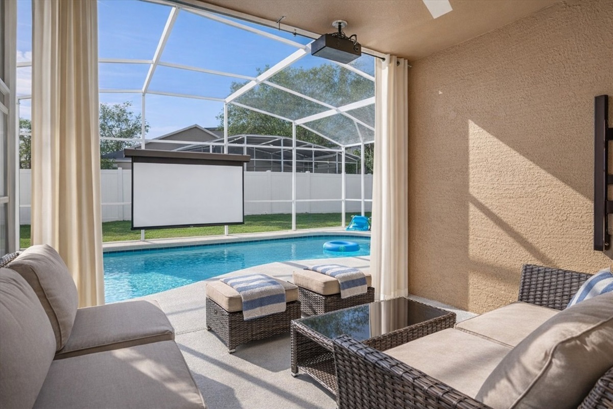 Relax in the covered patio with a view of the sparkling pool and outdoor poolside cinema screen