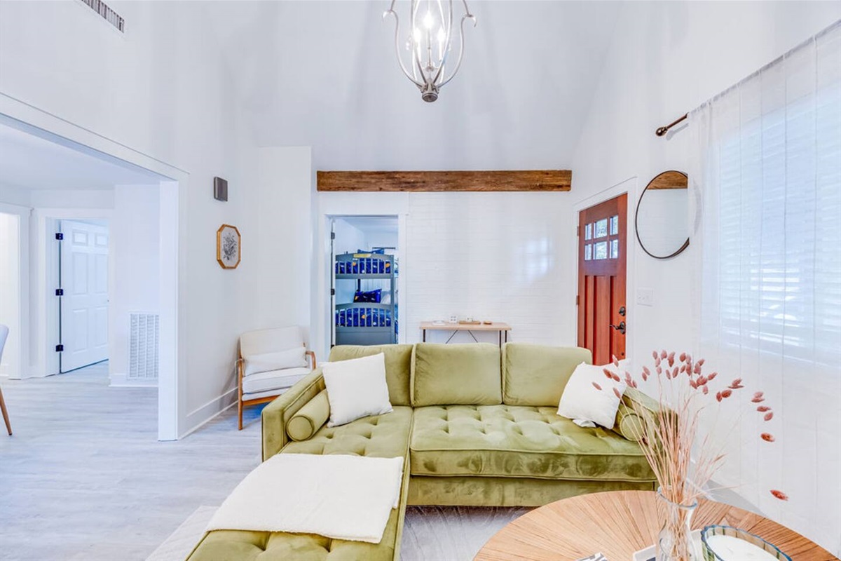 Bright and inviting living room with a stunning green sofa, perfect for relaxing and unwinding in style.

