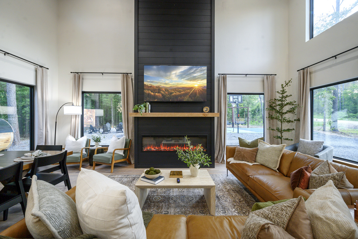 Gather here between adventures. Soaring ceilings, walls of windows & cozy seating bring the pines right in, with views of the sauna, fire pit and pickleball court just outside.
