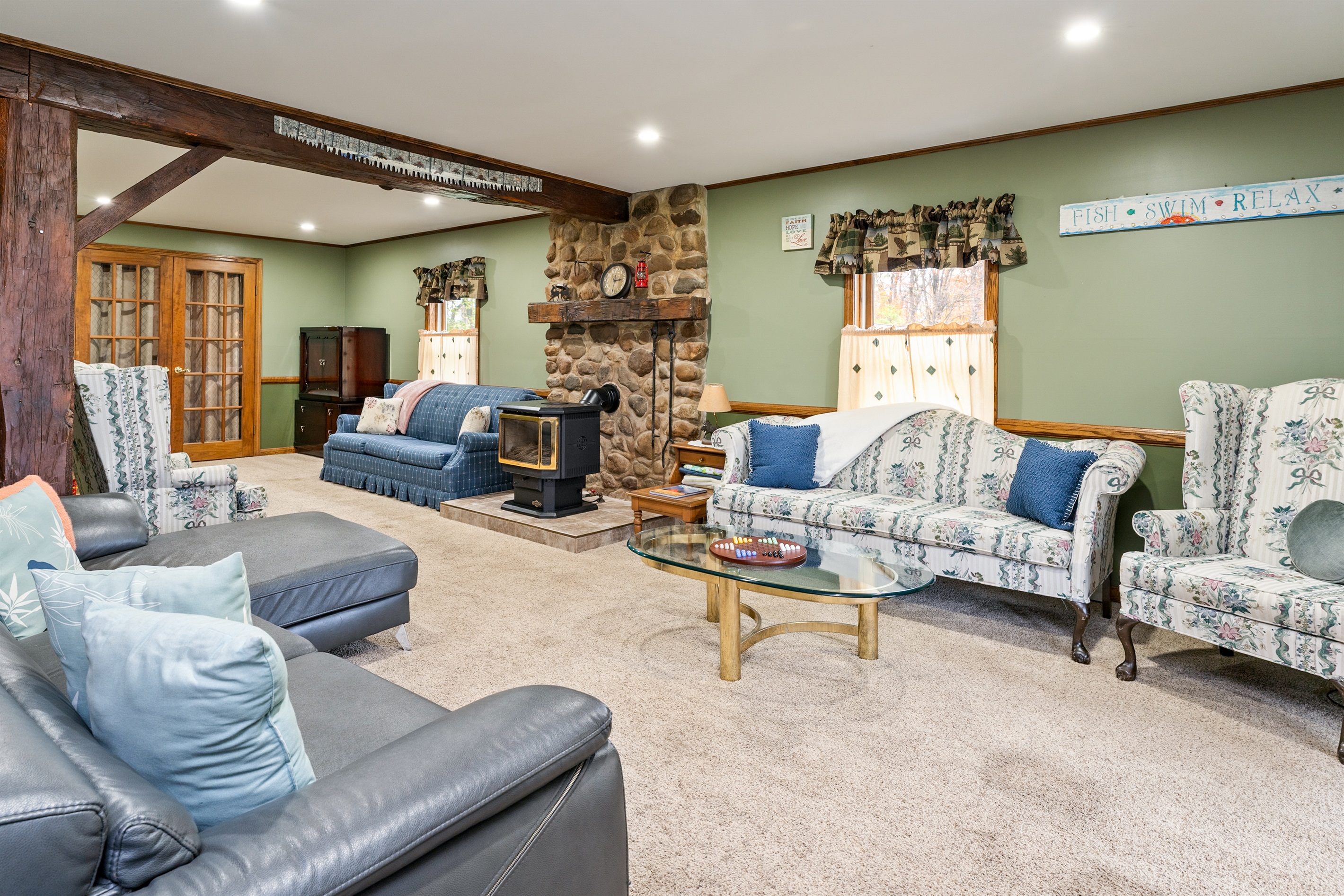 Cozy up in the spacious living room with a rustic stone fireplace and plush seating — perfect for family movie nights or lazy mornings.