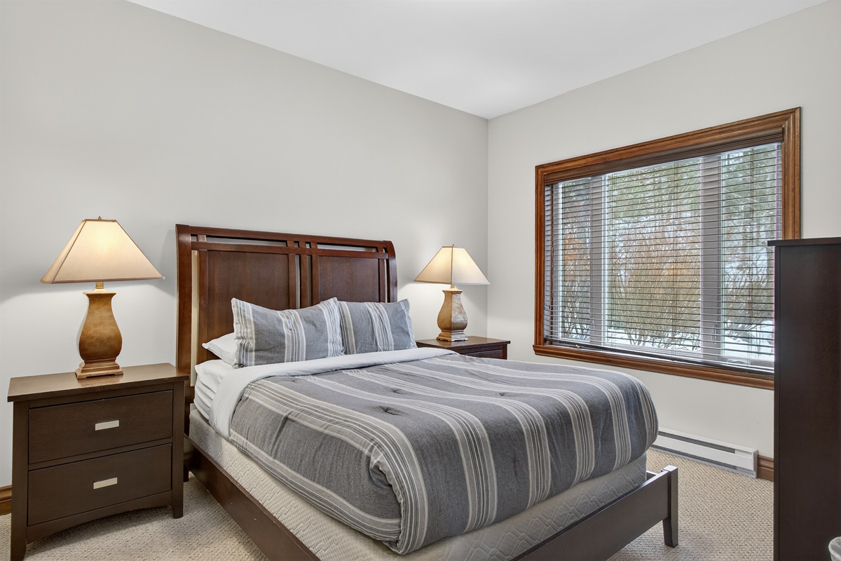 Guest bedroom w/ soft lighting & a peaceful setup.