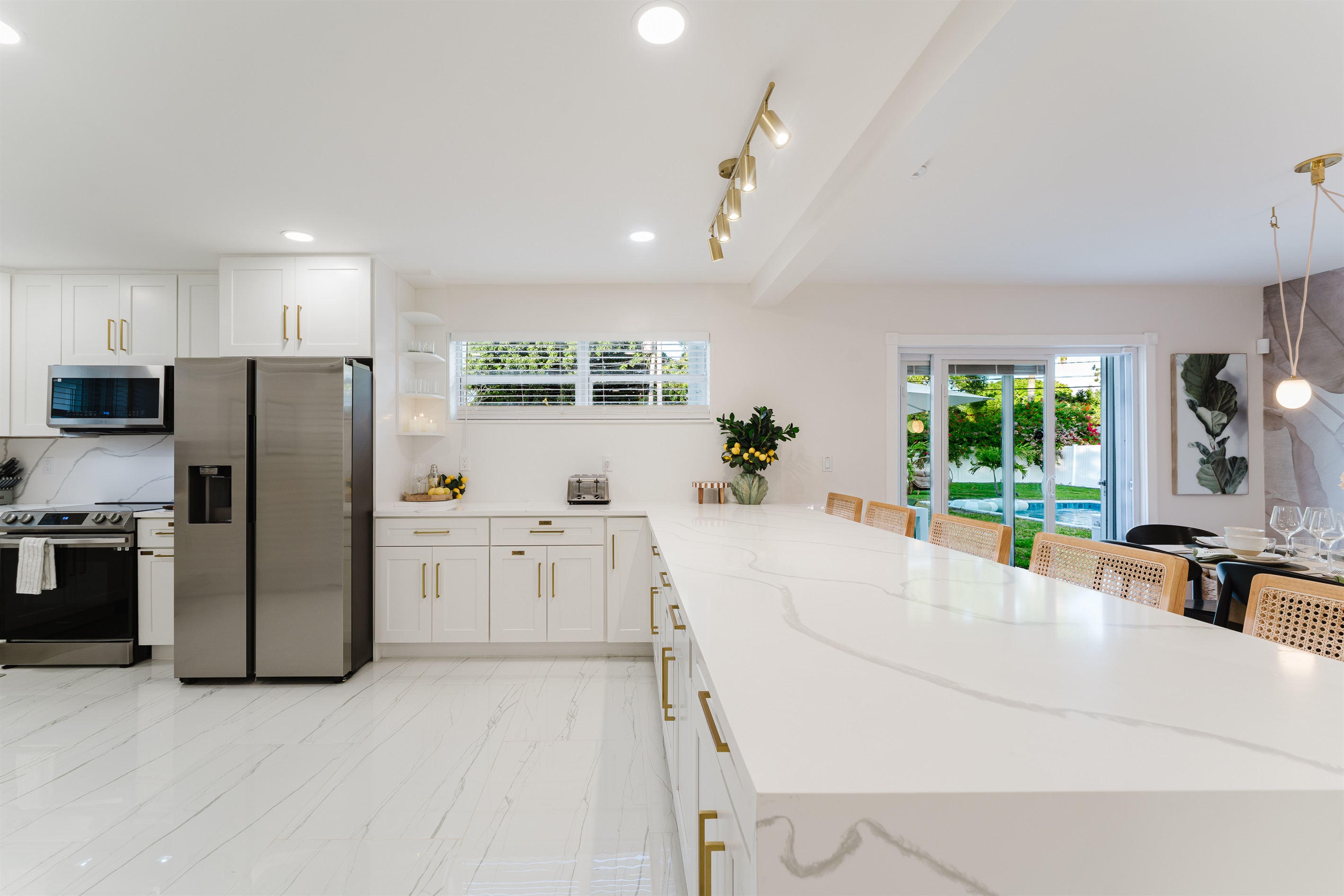 Bright, open-concept kitchen with quartz countertops, stainless steel appliances, and abundant prep space—perfect for family meals and entertaining. Fully stocked with a premium coffee setup, modern finishes, and seamless flow to dining and outdoor areas.