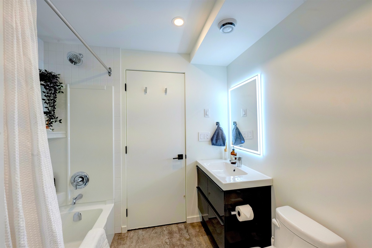 Full bathroom with modern vanity, tub/shower combo, and spa-style finishes.