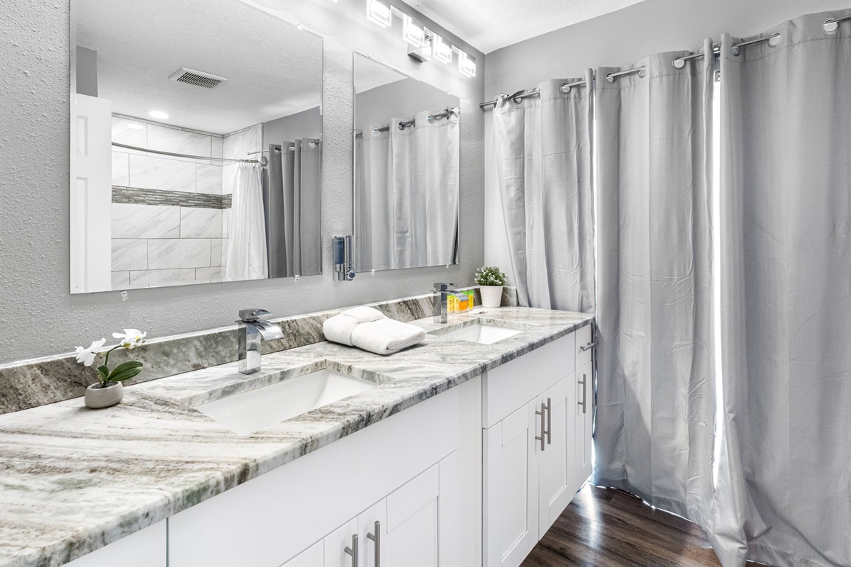 Enjoy the convenience of a stylish double-sink vanity, perfect for couples or shared stays, complete with ample storage and contemporary lighting.