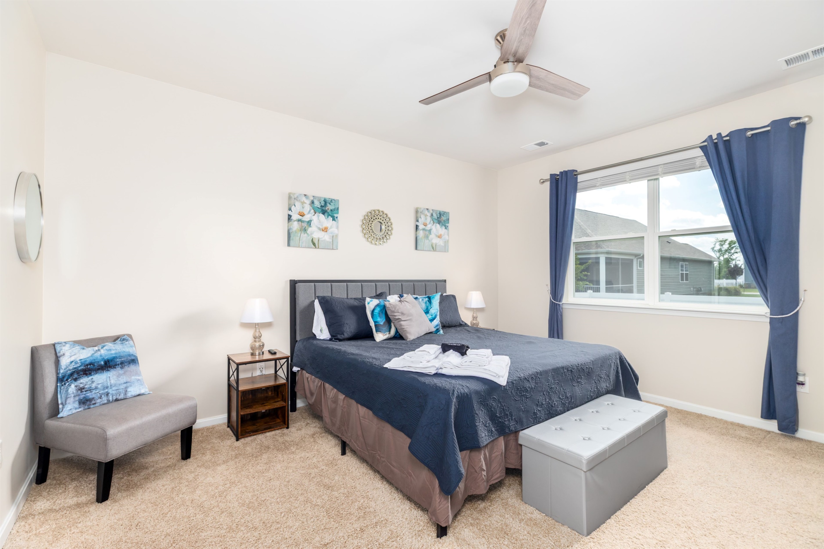 Tranquil primary suite with a plush king-size bed, cozy seating area, and USB chargers at the nightstand—your restful retreat after a day of sun and surf.