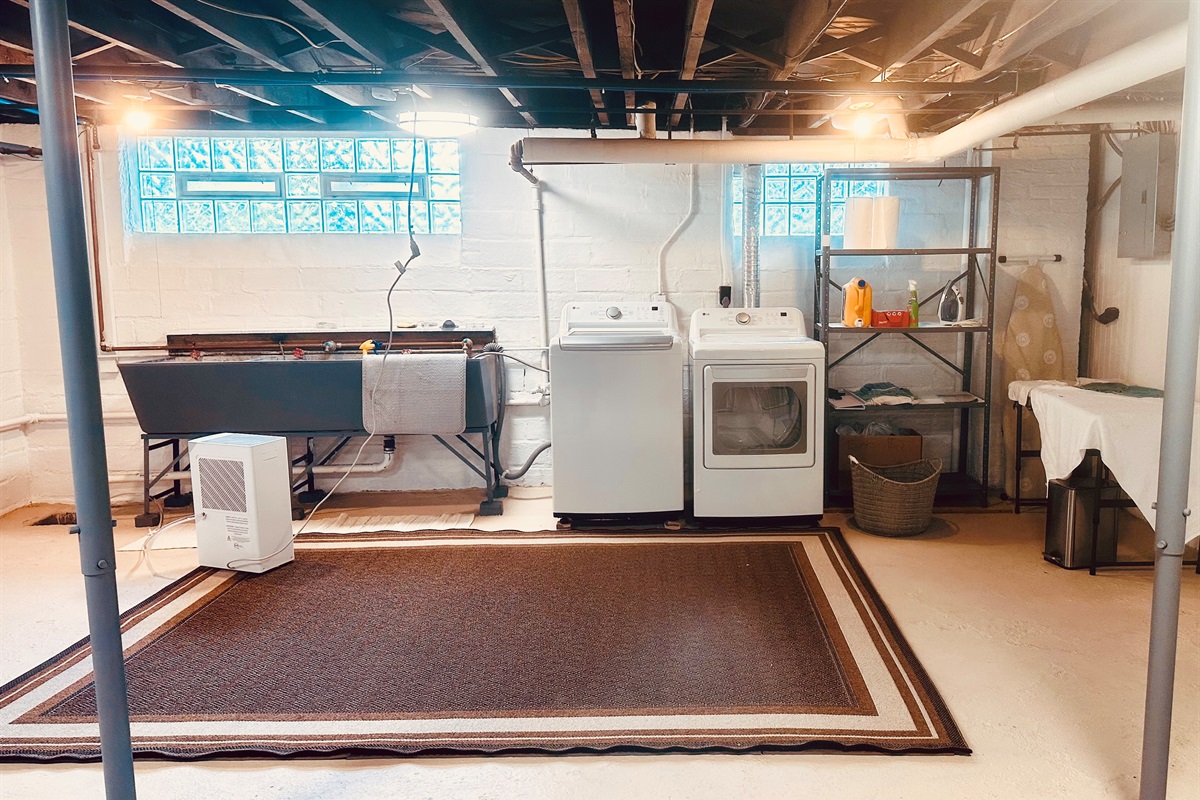 Newer washer & dryer, with three industrial utility sinks in the well lit basement.