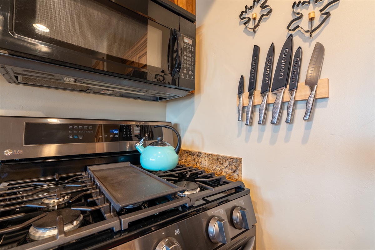 Fully equipped kitchen with gas range, microwave, and quality cookware for easy home-cooked meals.