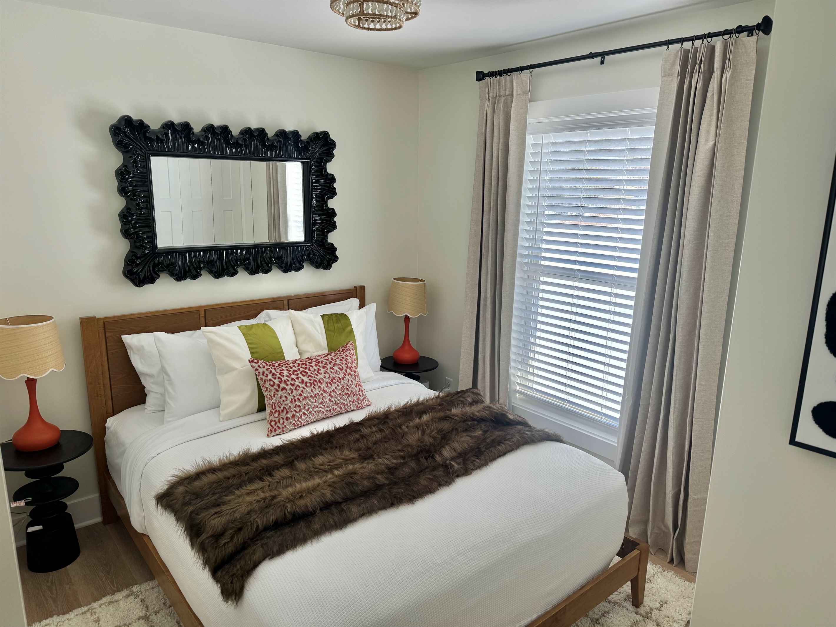 Cozy bedroom featuring a plush queen bed with professionally laundered linens, blackout curtains, and a noise machine for a restful night’s sleep. Thoughtfully styled with warm touches and natural light to help you relax and unwind.