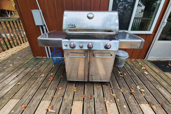 Large BBQ on rear balcony next to living room door for easy access to kitchen
