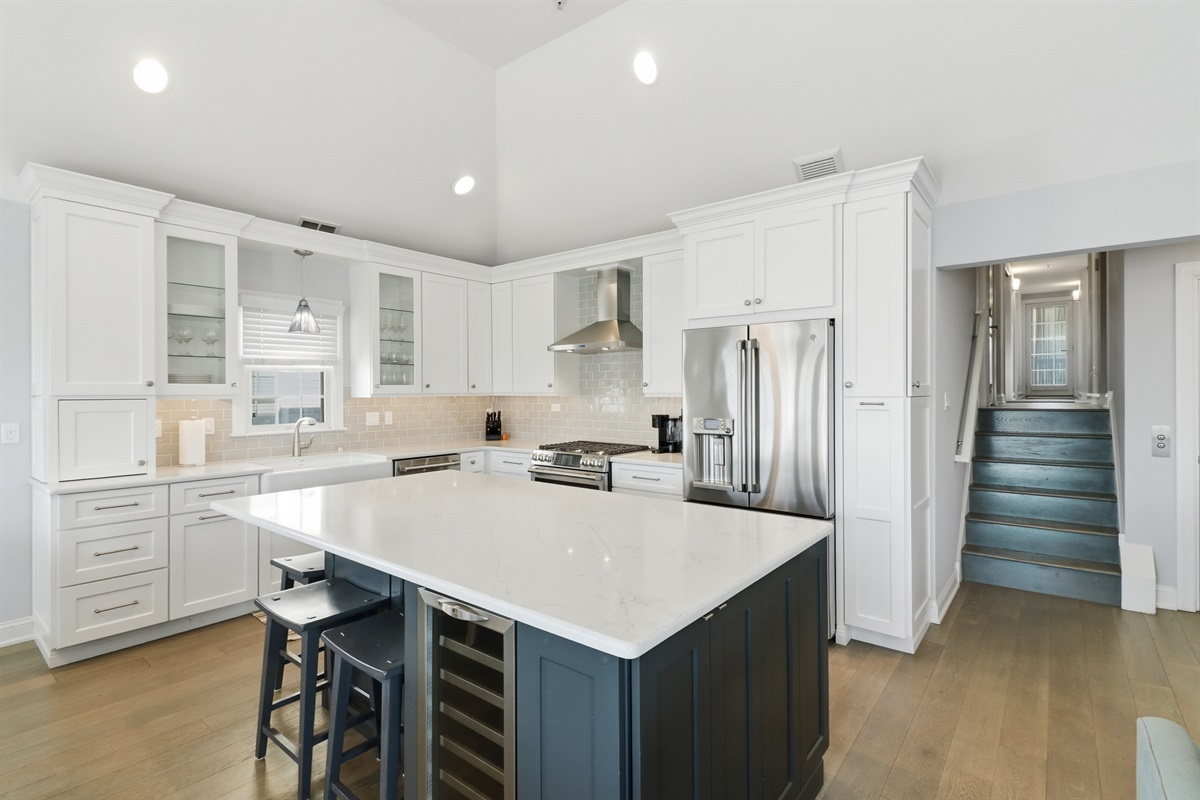 Fully-equipped kitchen with custom cabinetry, stainless appliances, and a 3-seat island for casual dining